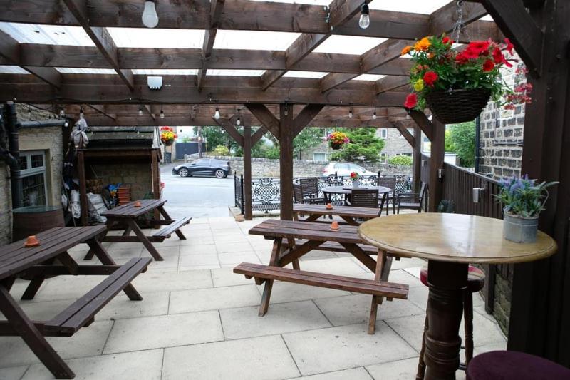 Covered beer garden with picnic benches at The Rushcart Inn